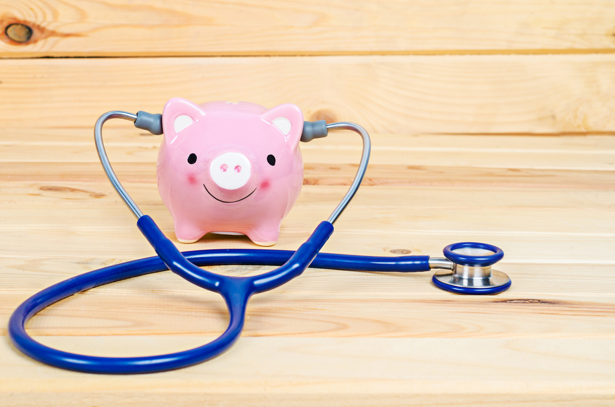 Happy piggy bank with stethoscope 